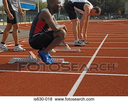 Stock Photo - Male sprinters preparing for race. Fotosearch