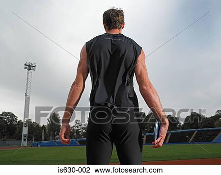 Stock Image - Rear view of discus thrower. Fotosearch