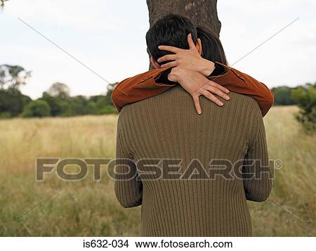 Couple kissing against tree View Large Photo Image Picture - Couple kissing against tree. Fotosearch