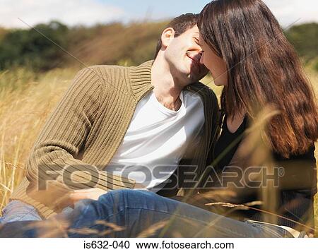 Couple kissing in field View Large Photo Image Stock Image - Couple kissing in field. Fotosearch