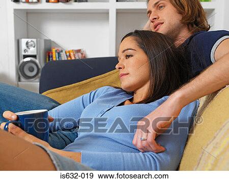 Couple relaxing on sofa View Large Photo Image Stock Photo - Couple relaxing on sofa. Fotosearch