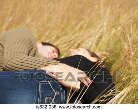 Stock Photo - Couple resting in field. Fotosearch
