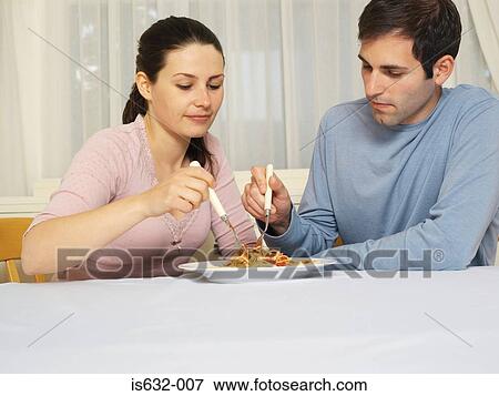 Couple sharing spaghetti bolognese View Large Photo Image Stock Photo - Couple sharing spaghetti bolognese. Fotosearch