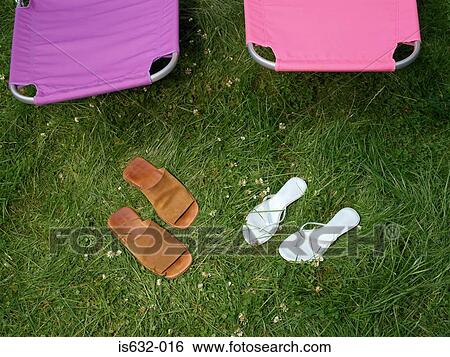 Stock Photograph - Sandals and lounge chairs in garden. Fotosearch