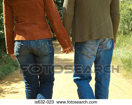 Stock Image - Young couple holding hands. Fotosearch
