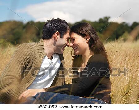 Young couple kissing in field View Large Photo Image Stock Image - Young couple kissing in field. Fotosearch