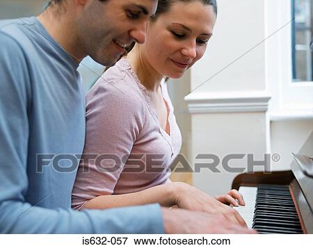 Young couple playing the piano View Large Photo Image Stock Photo - Young couple playing the piano. Fotosearch