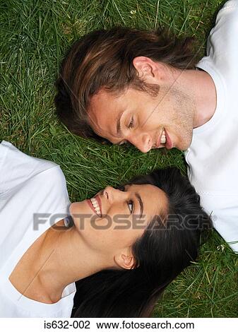 Young couple relaxing on grass View Large Photo Image Stock Image - Young couple relaxing on grass. Fotosearch