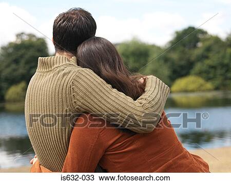 Young couple sitting near lake View Large Photo Image Stock Image - Young couple sitting near lake. Fotosearch