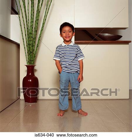 Boy standing in living room View Large Photo Image Stock Image - Boy standing in living room. Fotosearch