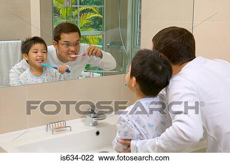 Stock Image - Father and son brushing teeth. Fotosearch