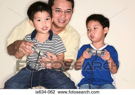 Father and sons playing video game View Large Photo Image Stock Image - Father and sons playing video game. Fotosearch