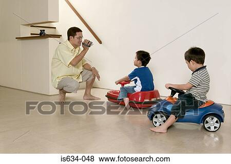 Father filming sons on camera View Large Photo Image Stock Photo - Father filming sons on camera. Fotosearch