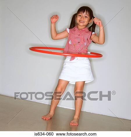 Stock Image - Girl playing with hula hoop. Fotosearch