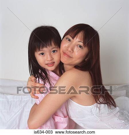 Mother cuddles young daughter View Large Photo Image Stock Image - Mother cuddles young daughter. Fotosearch
