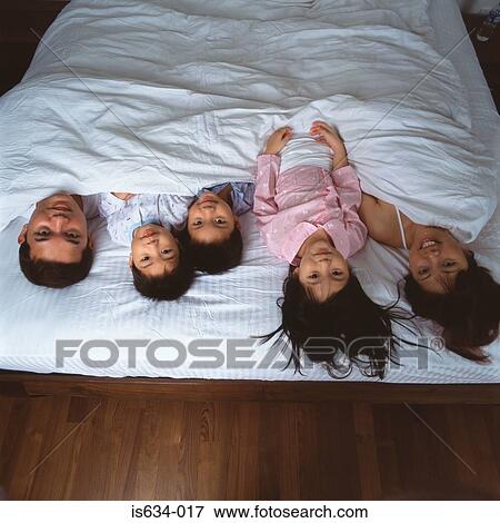 Stock Photo - Young family lying in bed. Fotosearch