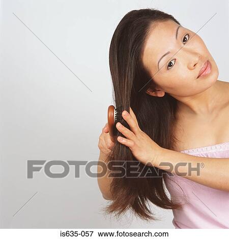 Asian woman brushing hair View Large Photo Image Stock Photo - Asian woman brushing hair. Fotosearch