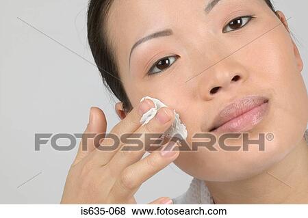 Woman applying moisturiser to cheek View Large Photo Image Stock Photo - Woman applying moisturiser to cheek. Fotosearch