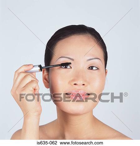 Young woman applying mascara View Large Photo Image Stock Image - Young woman applying mascara. Fotosearch