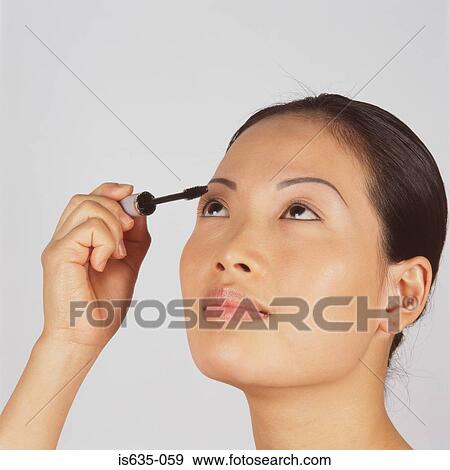 Young woman applying mascara View Large Photo Image Stock Photo - Young woman applying mascara. Fotosearch