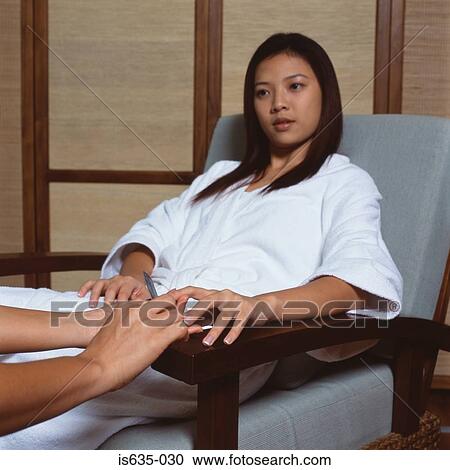 Young woman having a manicure View Large Photo Image Stock Image - Young woman having a manicure. Fotosearch