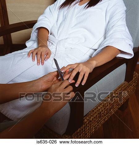 Young woman having a manicure View Large Photo Image Stock Photograph - Young woman having a manicure. Fotosearch