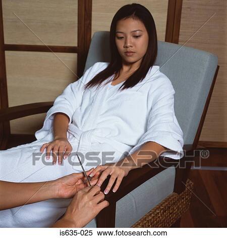 Young woman having a manicure View Large Photo Image Stock Photography - Young woman having a manicure. Fotosearch