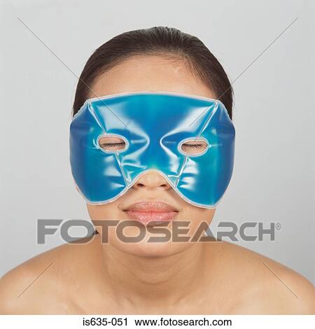 Stock Image - Young woman wearing eye gel. Fotosearch