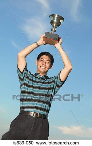 Asian man holding a trophy View Large Photo Image Stock Image - Asian man holding a trophy. Fotosearch