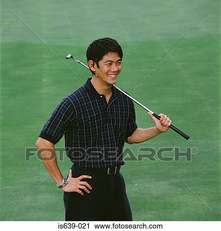 Stock Image - Man on golf green with bluetooth headset. Fotosearch