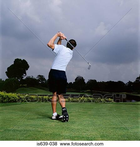 Man Swinging Golf Club Stock Photo