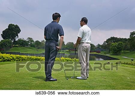 Two men playing golf View Large Photo Image Stock Photograph - Two men playing golf. Fotosearch