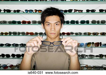 Stock Image - Man shopping for eyeglasses. Fotosearch