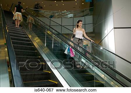 Stock Photo - Two women on escalator. Fotosearch