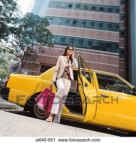 Woman leaving taxicab with shopping bags View Large Photo Image Stock Image - Woman leaving taxicab with shopping bags. Fotosearch