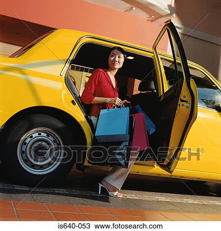 Woman leaving taxicab with shopping bags View Large Photo Image Stock Image - Woman leaving taxicab with shopping bags. Fotosearch