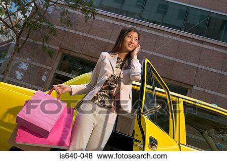 Woman leaving taxicab with shopping bags View Large Photo Image Stock Photo - Woman leaving taxicab with shopping bags. Fotosearch