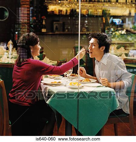 Stock Image - Young couple in restaurant. Fotosearch