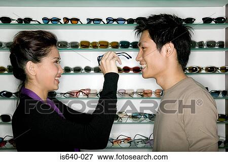 Stock Photo - Young couple shopping for eyeglasses. Fotosearch
