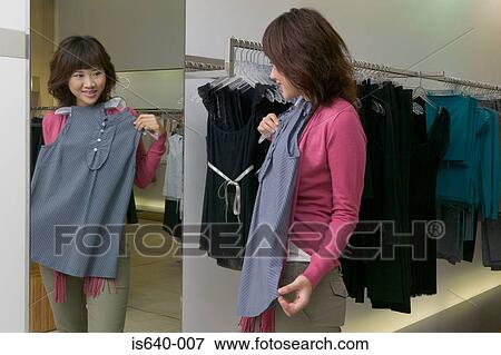 Young woman in clothes store View Large Photo Image Stock Photo - Young woman in clothes store. Fotosearch