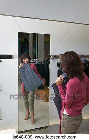 Young woman in clothes store View Large Photo Image Stock Photo - Young woman in clothes store. Fotosearch