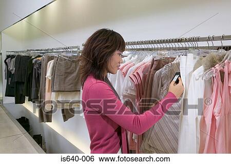 Young woman in clothes store View Large Photo Image Stock Photograph - Young woman in clothes store. Fotosearch