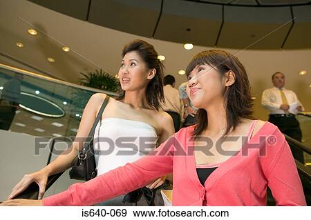 Young women on escalator View Large Photo Image Stock Photo - Young women on escalator. Fotosearch