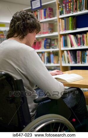 Stock Image - Disabled man reading in library. Fotosearch