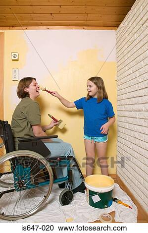 Stock Image - Disabled mother and daughter decorating. Fotosearch