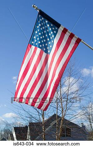 Picture - America flag flying outside house. Fotosearch