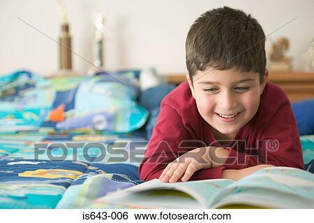 Boy reading a book and smiling View Large Photo Image Stock Photograph - Boy reading a book and smiling. Fotosearch
