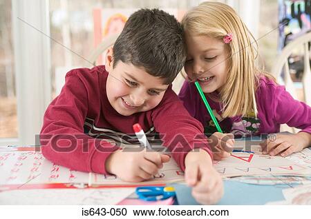 Stock Image - Brother and sister doing homework. Fotosearch