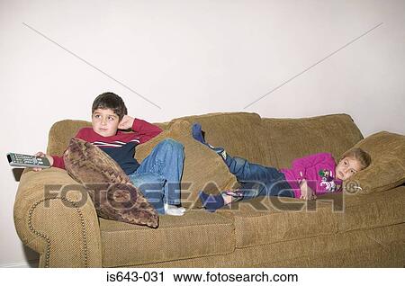 Brother and sister on the sofa watching television View Large Photo Image Stock Image - Brother and sister on the sofa watching television. Fotosearch