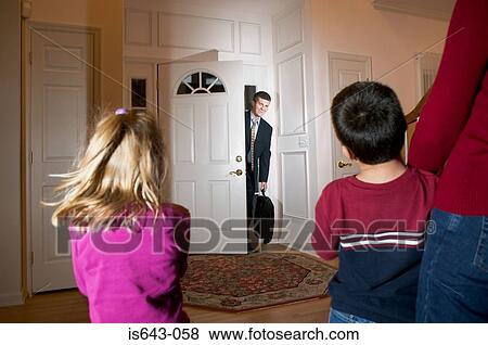 Stock Photo - Family greeting businessman as he arrives home. Fotosearch